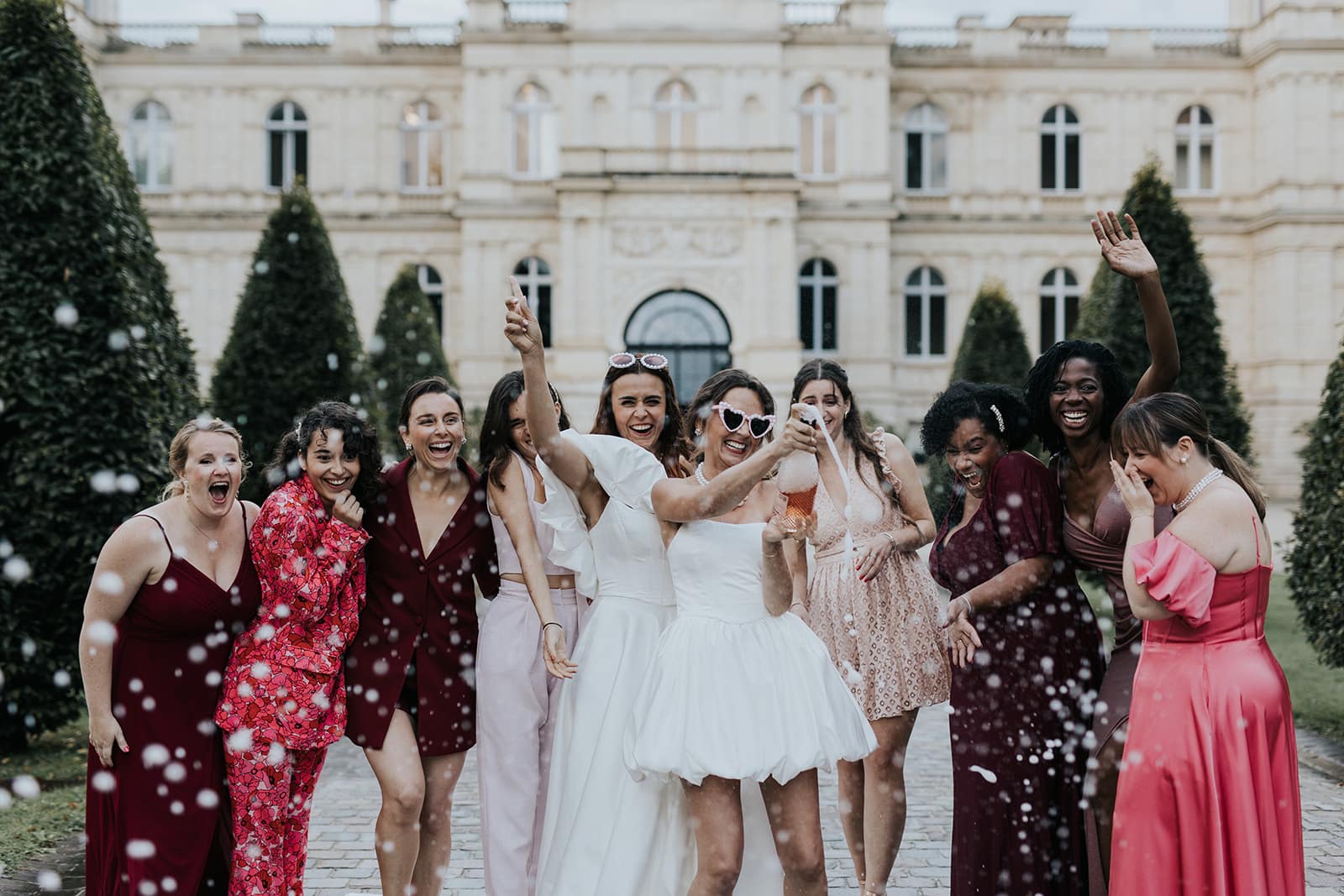 Une mariée entourée de ses proches ouvre le champagne après la cérémonie